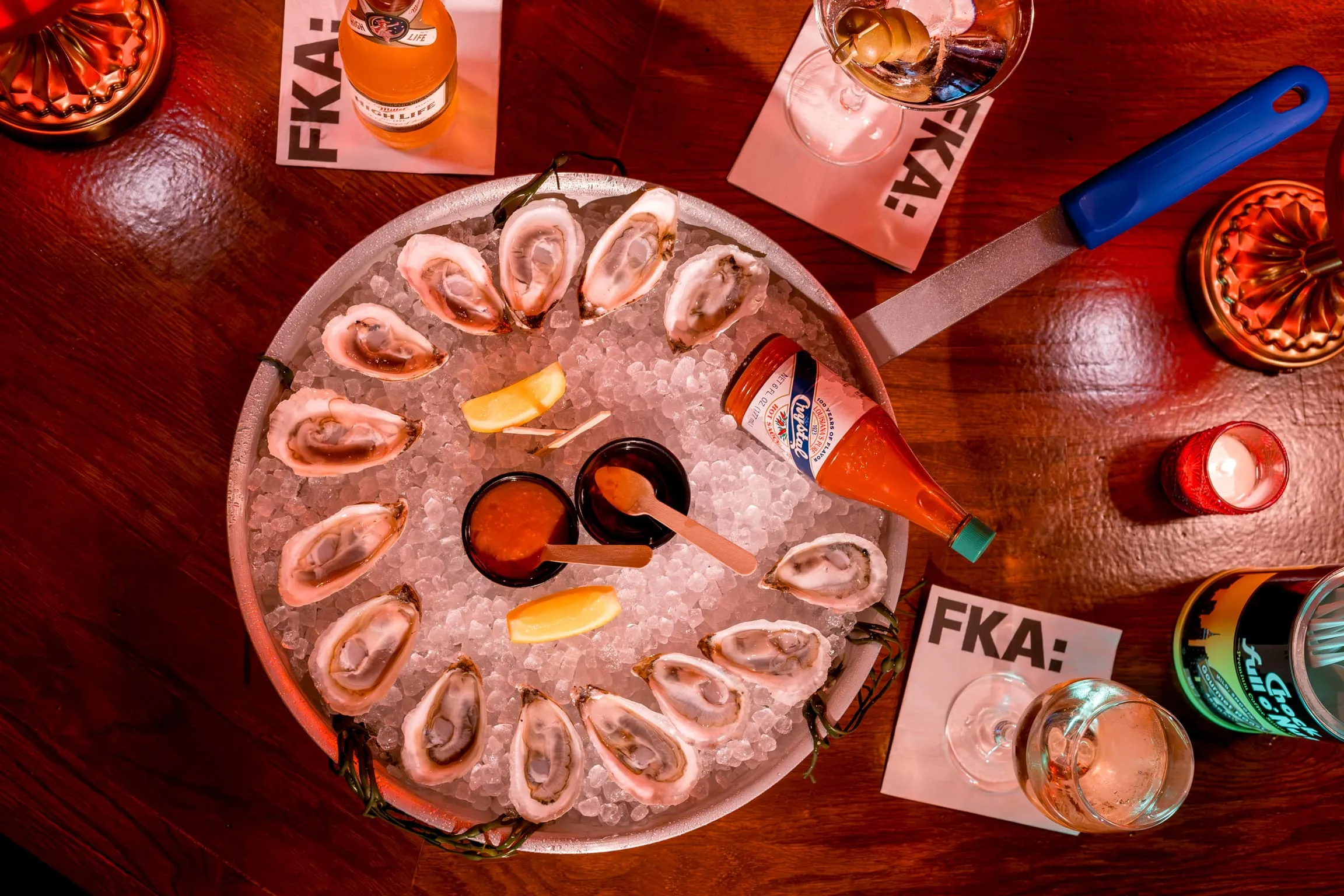 A dozen oysters on crushed ice with mignonette, Crystal hot sauce, and lemon at FKA: Formerly Known As